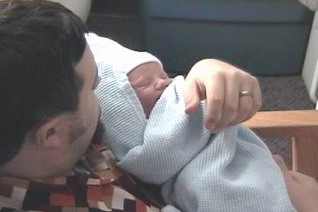 Paul holding newborn Logan
